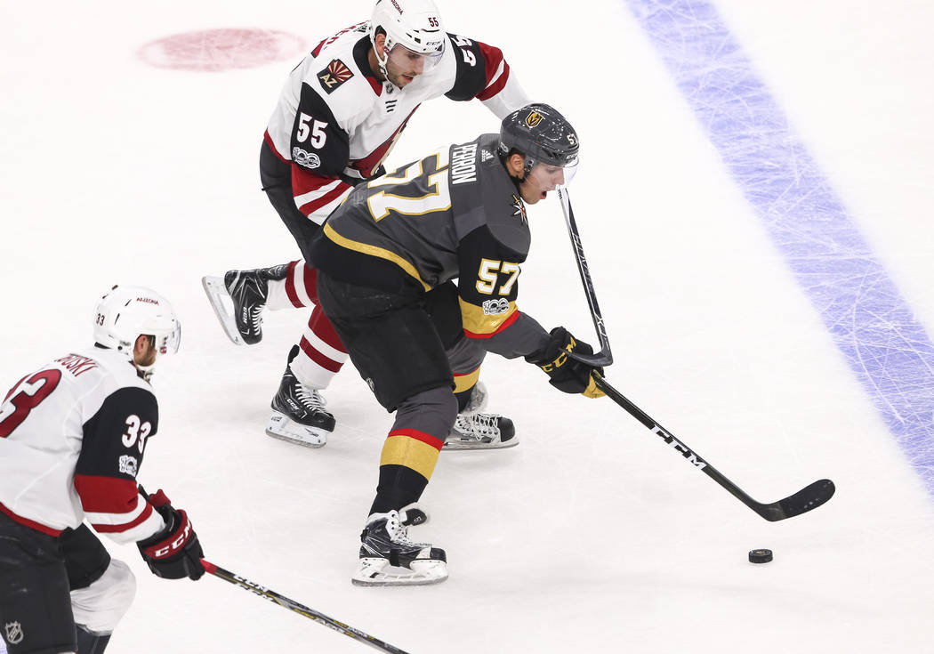 Vegas Golden Knights left wing David Perron (57) controls the puck as he is pressured by Arizona Coyotes defenseman Jason Demers (55) and Coyotes defenseman Alex Goligoski (33) during the first pe ...