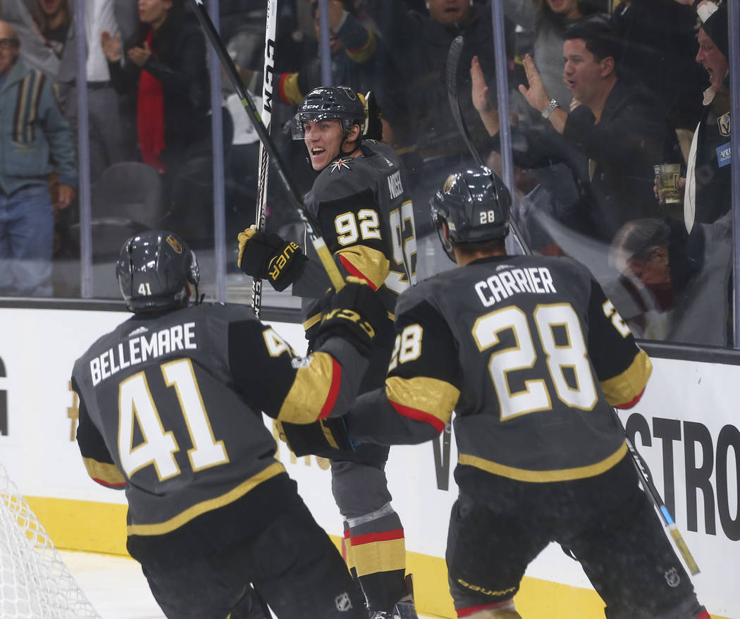 Vegas Golden Knights' Tomas Nosek (92) celebrates with Pierre-Edouard Bellemare (41) and William Carrier (28) after Nosek scored the first goal of the night against the Arizona Coyotes during an N ...