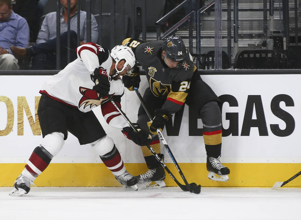 Vegas Golden Knights' Oscar Lindberg (24) and Arizona Coyotes' Brad Richardson (15) fight to control the puck during an NHL hockey game at T-Mobile Arena in Las Vegas on Tuesday, Oct. 10, 2017. Ch ...