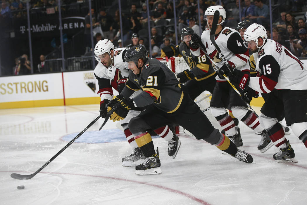 Vegas Golden Knights' Cody Eakin (21) chases down the puck against Arizona Coyotes' Jason Demers, left, during an NHL hockey game at T-Mobile Arena in Las Vegas on Tuesday, Oct. 10, 2017. The Gold ...