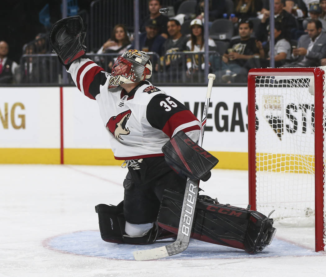 The puck flies above the head of Arizona Coyotes goalie Louis Domingue (35) during an NHL hockey game against the Vegas Golden Knights at T-Mobile Arena in Las Vegas on Tuesday, Oct. 10, 2017. The ...
