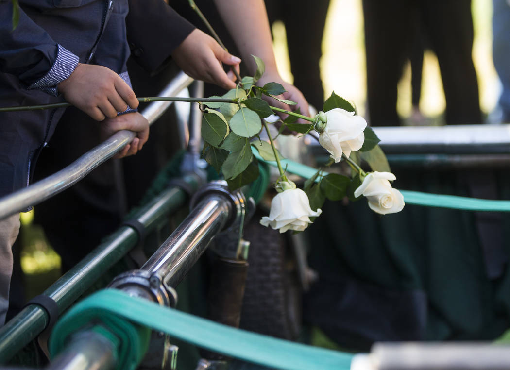 People leave roses during funeral services for Erick Silva at Davis Funeral Home & Memorial Park in Las Vegas on Thursday, Oct. 12, 2017. Silva was working as a security guard at the Route 91  ...