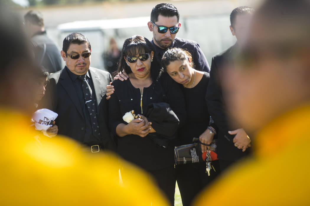Gregorio De La Rosa, left, and Angelica Cervantes, mother of Erick Silva, second from left, during funeral services for Silva at Davis Funeral Home & Memorial Park in Las Vegas on Thursday, Oc ...
