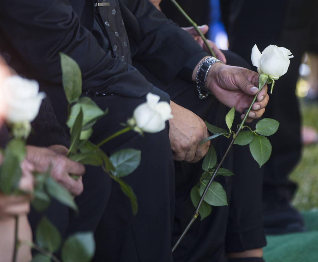 Gregorio De La Rosa, stepfather of Erick Silva, holds a rose during funeral services for Silva at Davis Funeral Home & Memorial Park in Las Vegas on Thursday, Oct. 12, 2017. Silva was working ...