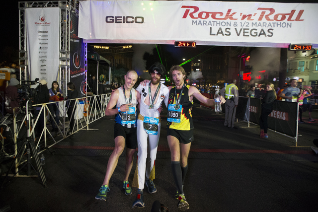 Top three runners from left, Chip O'hara, who finished third, Michael Wardian, who finished first, and Eric Fitzpatrick who finished second, pose after the Rock-n-Roll Marathon at the Strip near ...