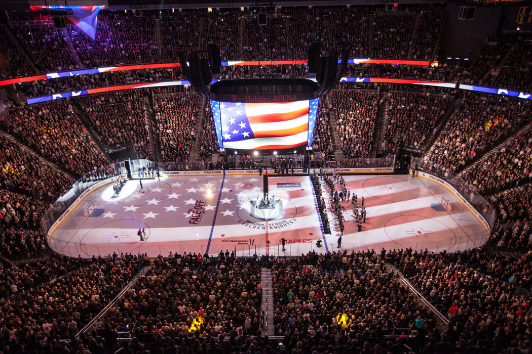 The American flag is displayed on the hockey ring during a ceremony honoring victims and first responders of the Route 91 Harvest Festival shooting before the start of an NHL hockey game between t ...