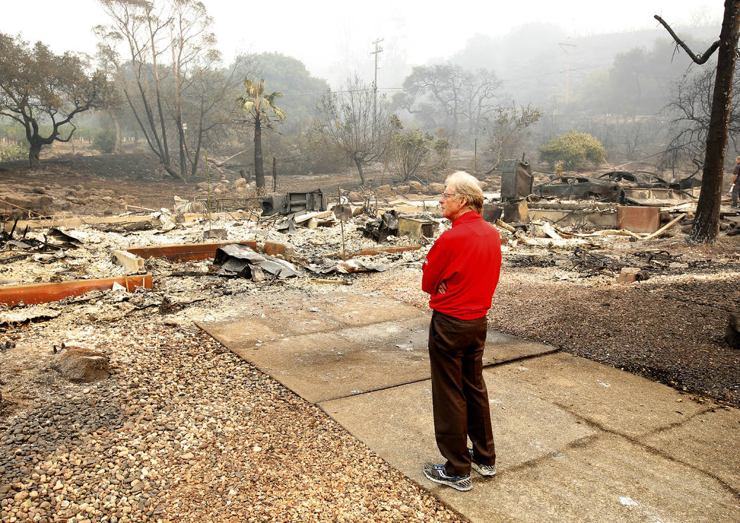 Mike Rippey looks over the burned out remains of his parents home at the Silverado Resort, Tuesday, Oct. 10, 2017, in Napa, Calif. Charles Rippey, 100 and his wife Sara, 98, died when wind whipped ...