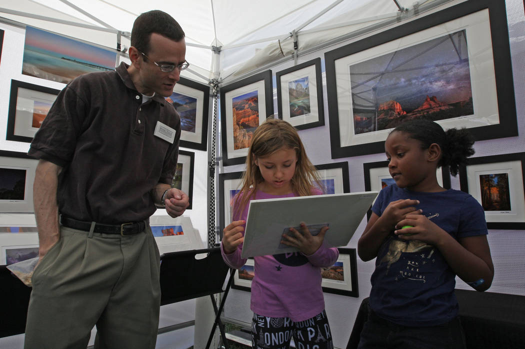 Michael Tessler, left, explains how he takes photos to Gianna Kelley, 8