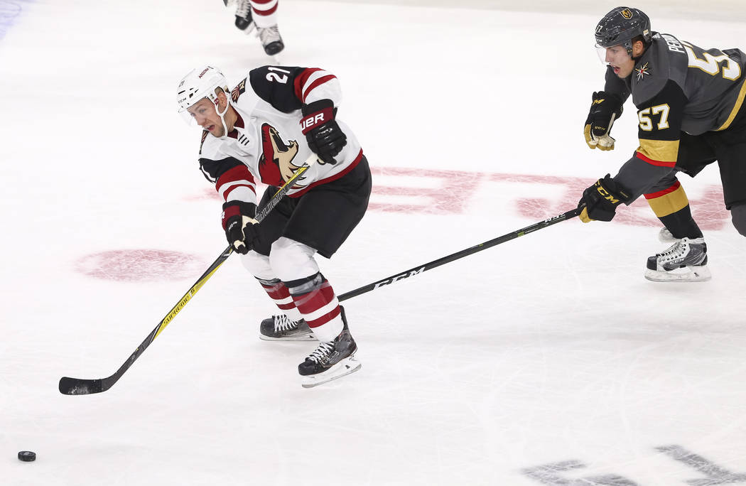 Arizona Coyotes center Derek Stepan (21) passes the puck as Vegas Golden Knights left wing David Perron (57) trails behind during the third period of an NHL hockey game between the Vegas Golden Kn ...