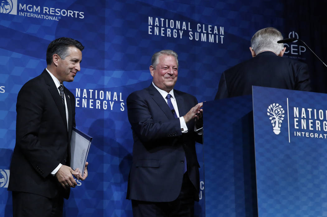 Former U.S. Senate Harry Reid, right, (D-Nev.) leaves the podium as Gov. Brian Sandoval, left, and former Vice President Al Gore look on during the National Clean Energy Summit Friday, Oct. 13, 20 ...