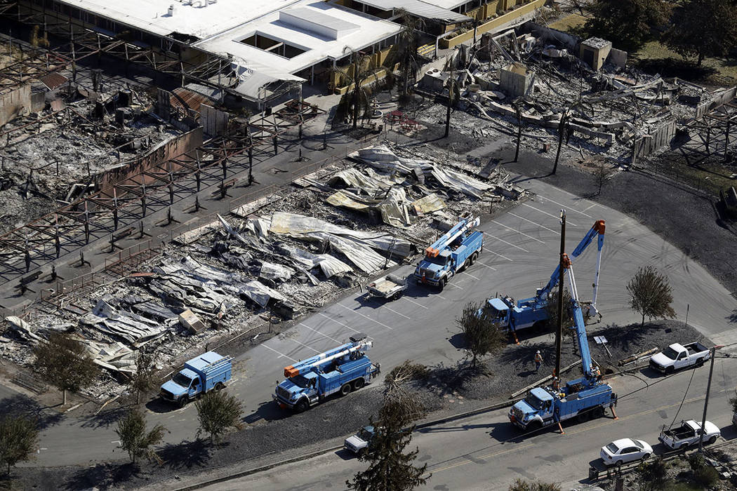 PG&E crews work on restoring power lines in a fire ravaged neighborhood in an aerial view in the aftermath of a wildfire Saturday, Oct. 14, 2017, in Santa Rosa, Calif. (AP Photo/Marcio Jose Sa ...