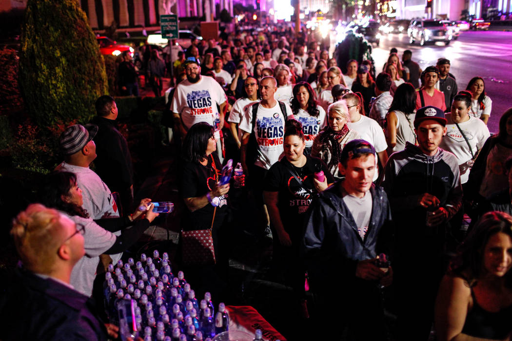 People walk along the Strip during the Vegas Strong Las Vegas Strip Walk honoring the victims of the Route 91 Harvest Festival shooting in Las Vegas, Sunday, Oct. 15, 2017. Joel Angel Juarez Las V ...