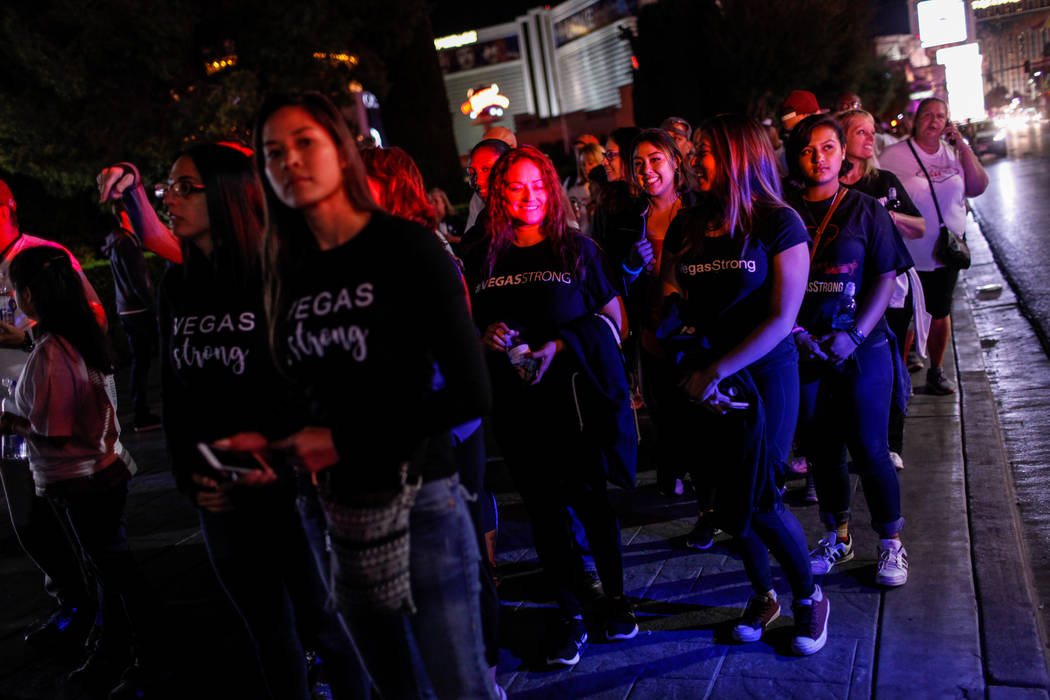 People walk along the Strip during the Vegas Strong Las Vegas Strip Walk honoring the victims of the Route 91 Harvest Festival shooting in Las Vegas, Sunday, Oct. 15, 2017. Joel Angel Juarez Las V ...