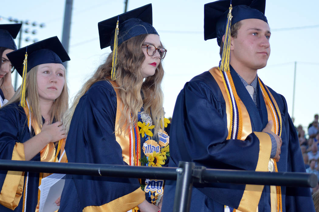 Salutatorian Alea Lehr, left, and valedictorians Mira Newby center, and Michael Martinelli listen to the national anthem during Boulder City High School's graduation ceremony on Friday evening at  ...