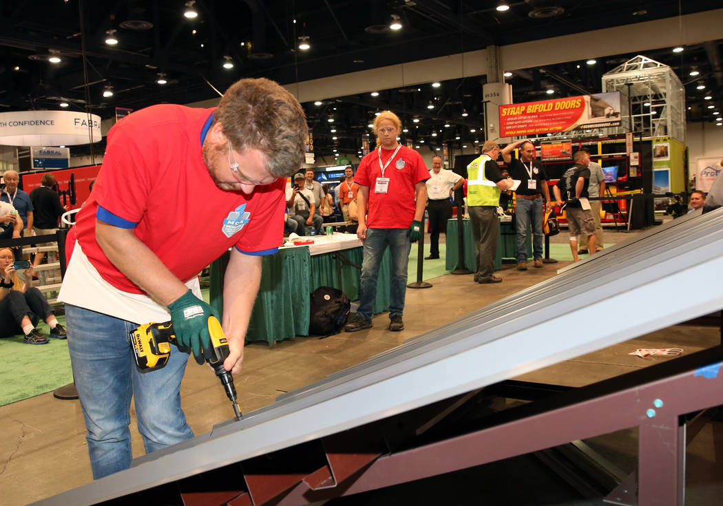 Marc Vlietstra participates in Screw Gun Challenge as his brother Seth, right, looks on during the 2017 MetalCon Expo at the Las Vegas Convention Center Wednesday, Oct. 18, 2017. Contestants insta ...