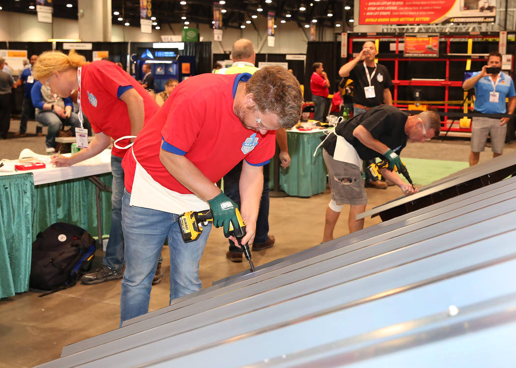 Marc Vlietstra, center, participates in Screw Gun Challenge during the 2017 MetalCon Expo at the Las Vegas Convention Center Wednesday, Oct. 18, 2017. Contestants install a series of self-drilling ...