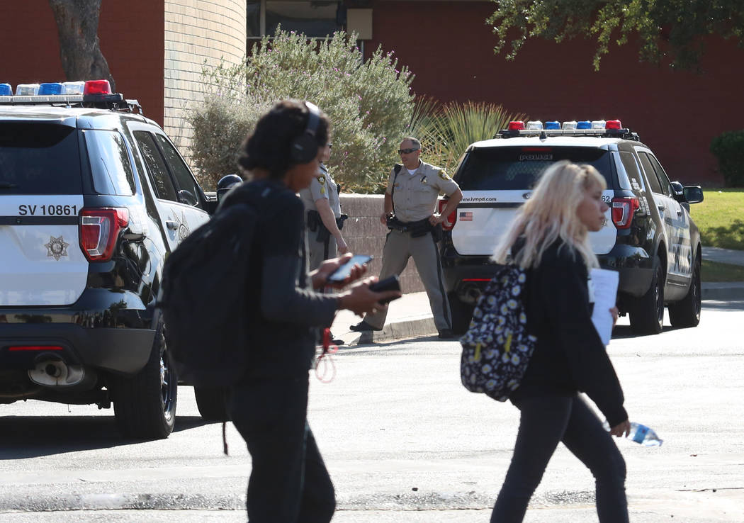 Students at Clark High School walk past Las Vegas police officers Monday, Oct. 16, 2017. A 16-year-old student was taken to University Medical Center after she was stabbed by another 14-year-old f ...
