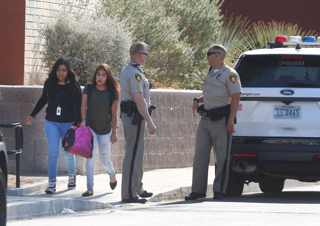 Students at Clark High School walk past Las Vegas police officers Monday, Oct. 16, 2017. A 16-year-old student was taken to University Medical Center after she was stabbed by another 14-year-old f ...