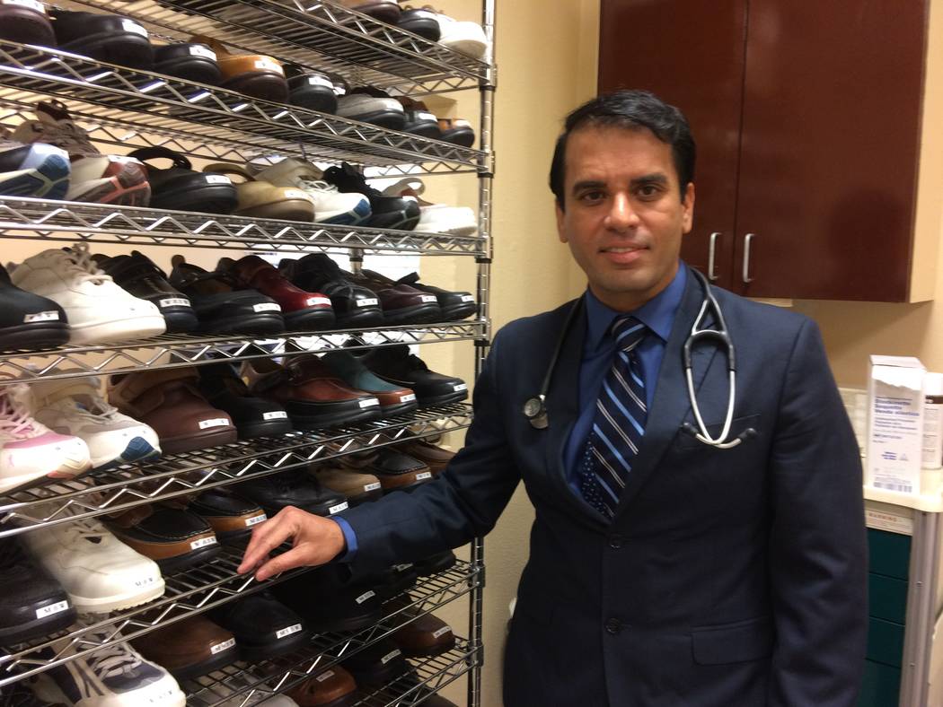 Dr. Dhaval Shah, poses beside a rack of shoes Sept. 21, 2017, which have  special insoles for diabetic people at CIDS, 2435 Fire Mesa St, Suite 120.  The facility takes a whole-body