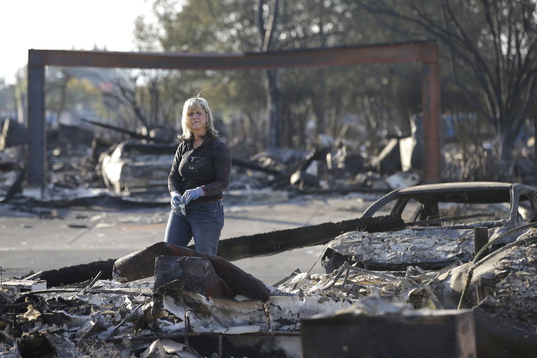 Debbie Wolfe looks over the burned ruins of her home of 30 years Tuesday, Oct. 17, 2017, in Santa Rosa, Calif. A massive deadly wildfire swept through the area last week destroying thousands of ho ...