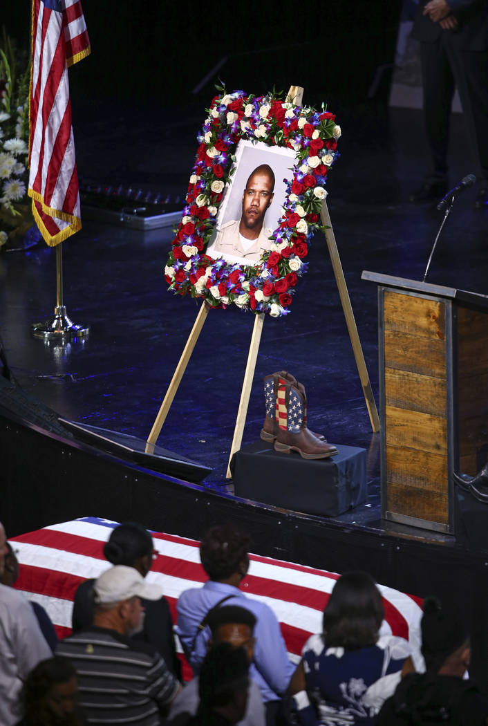 Boots and a picture of Las Vegas police officer Charleston Hartfield are on display at his funeral, Friday, Oct. 20, 2017, in Henderson, Nev. Hartfield was killed by a gunman shooting from a hotel ...