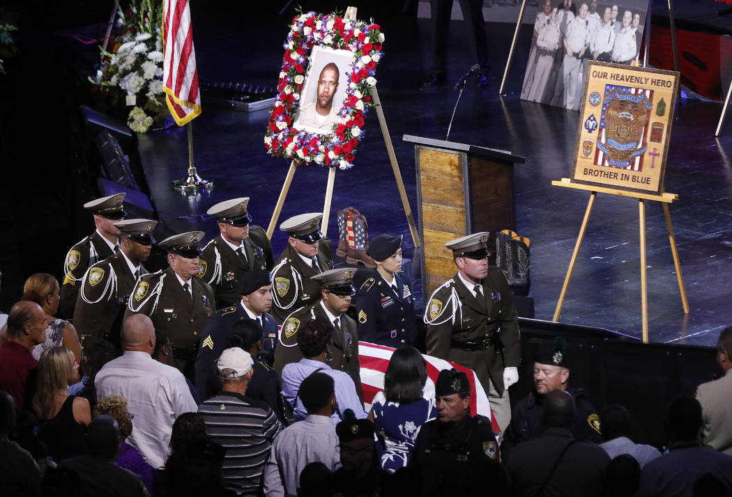 Pallbearers move the casket of Las Vegas police officer Charleston Hartfield, Friday, Oct. 20, 2017, in Henderson, Nev. Hartfield was killed by a gunman shooting from a hotel into a crowded outdoo ...