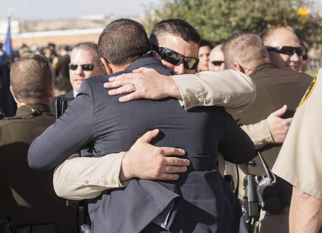 Metro officers comfort each other outside Central Church before the start of the service for Charleston Hartfield, the off-duty officer killed during the Route 91 shooting on Friday, October, 20, ...
