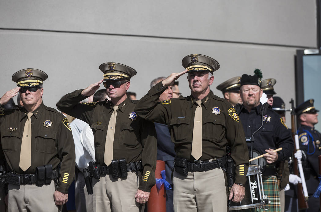 Sheriff Joe Lombardo, right, salutes the funeral procession for Metro officer Charleston Hartfield at Central Church during a service for the off-duty officer killed during the Route 91 shooting o ...