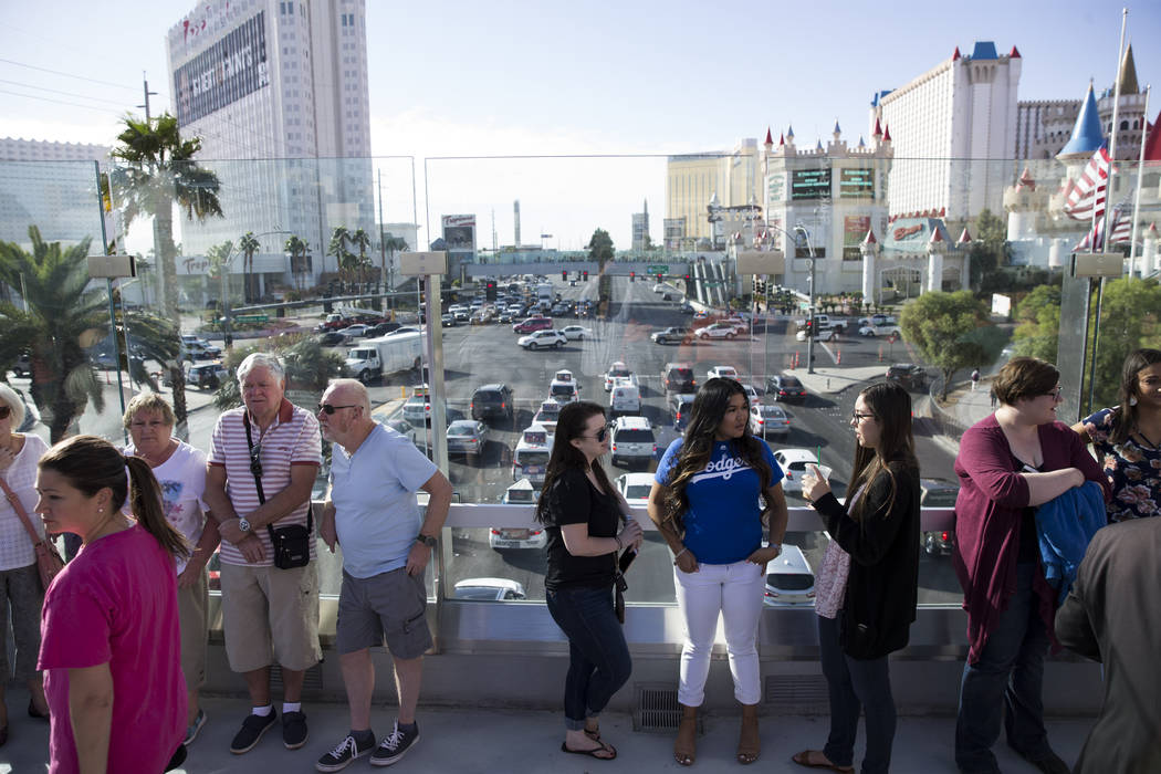 People wait for the funeral procession of Las Vegas police officer and Nevada National Guard veteran Charleston Hardfield, at the intersection of Tropicana Ave and Las Vegas Bouelevard in Las Vega ...