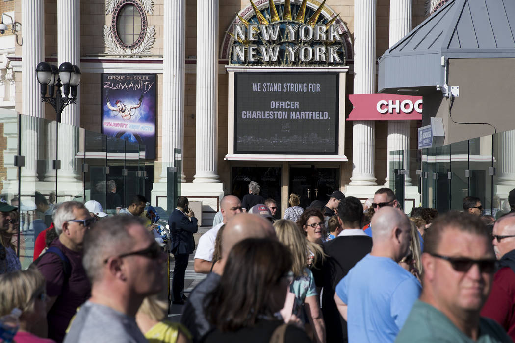 People wait for the funeral procession of Las Vegas police officer and Nevada National Guard veteran Charleston Hardfield, at the intersection of Tropicana Ave and Las Vegas Bouelevard in Las Vega ...