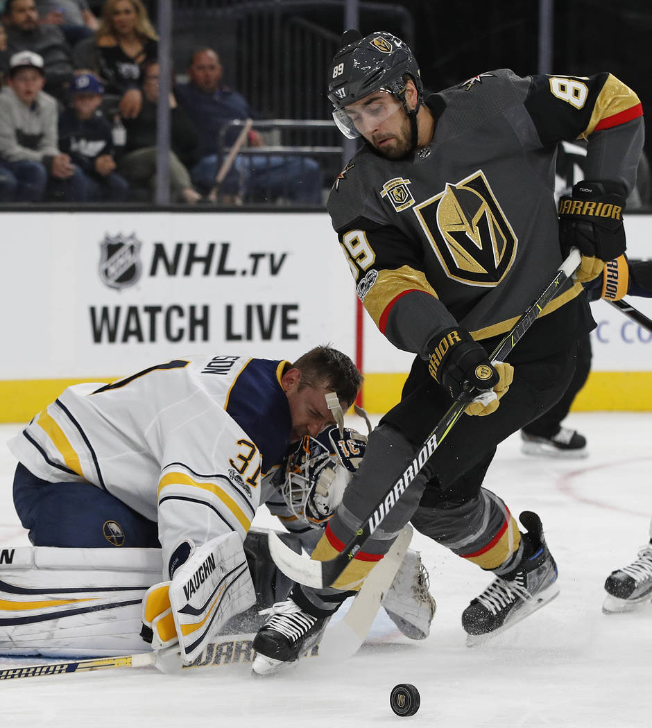 Buffalo Sabres goalie Chad Johnson loses his helmut while blocking a shot by Vegas Golden Knights right wing Alex Tuch during the first period of an NHL hockey game Tuesday, Oct. 17, 2017, in Las  ...