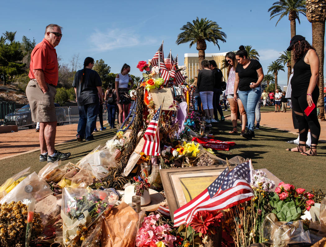Steve Adams of Colorado and Henderson, 68, left, visits a memorial at the Welcome to Fabulous Las Vegas sign in Las Vegas, Monday, Oct. 16, 2017, honoring the victims of the Route 91 Harvest Festi ...