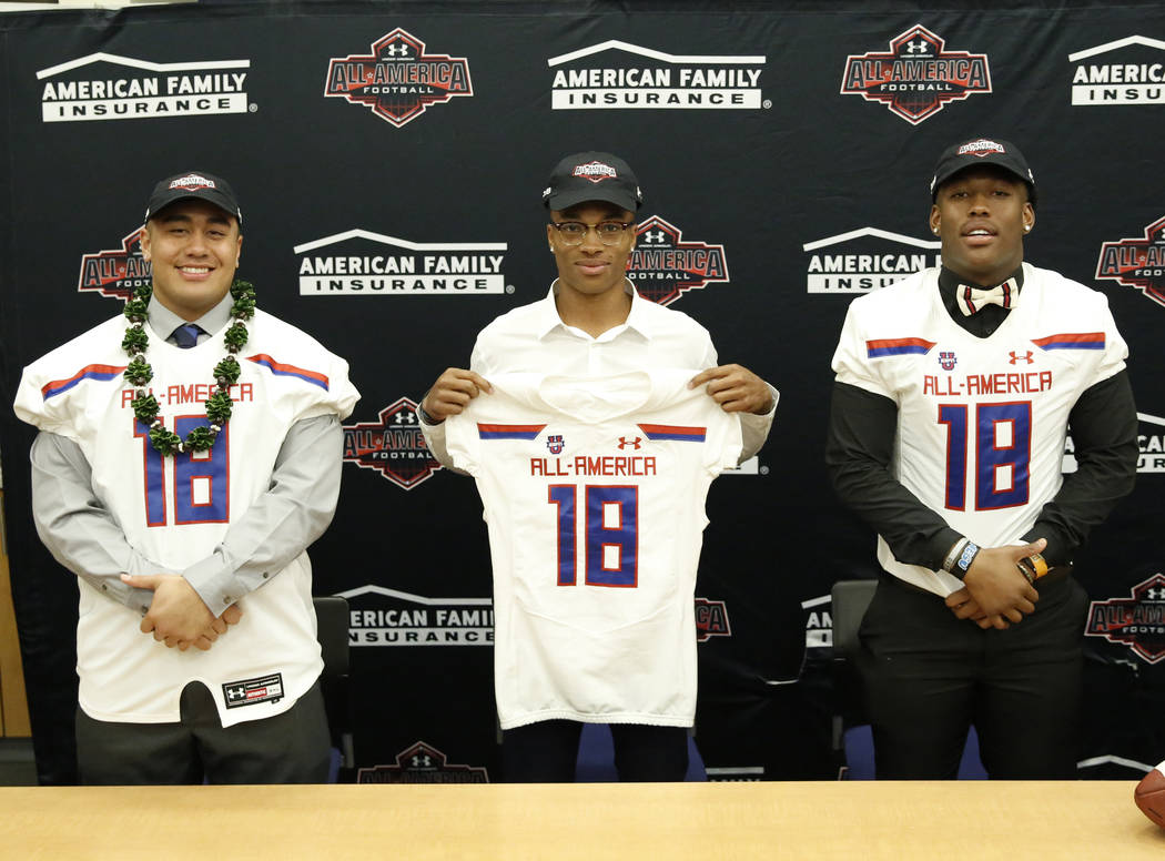 Bishop Gorman's offensive guard Jacob Isaia, left, quarterback Dorian Thompson-Robinson and tight end Brevin Jordan, right, receive their honorary All America Game jersey at their school Wednesday ...