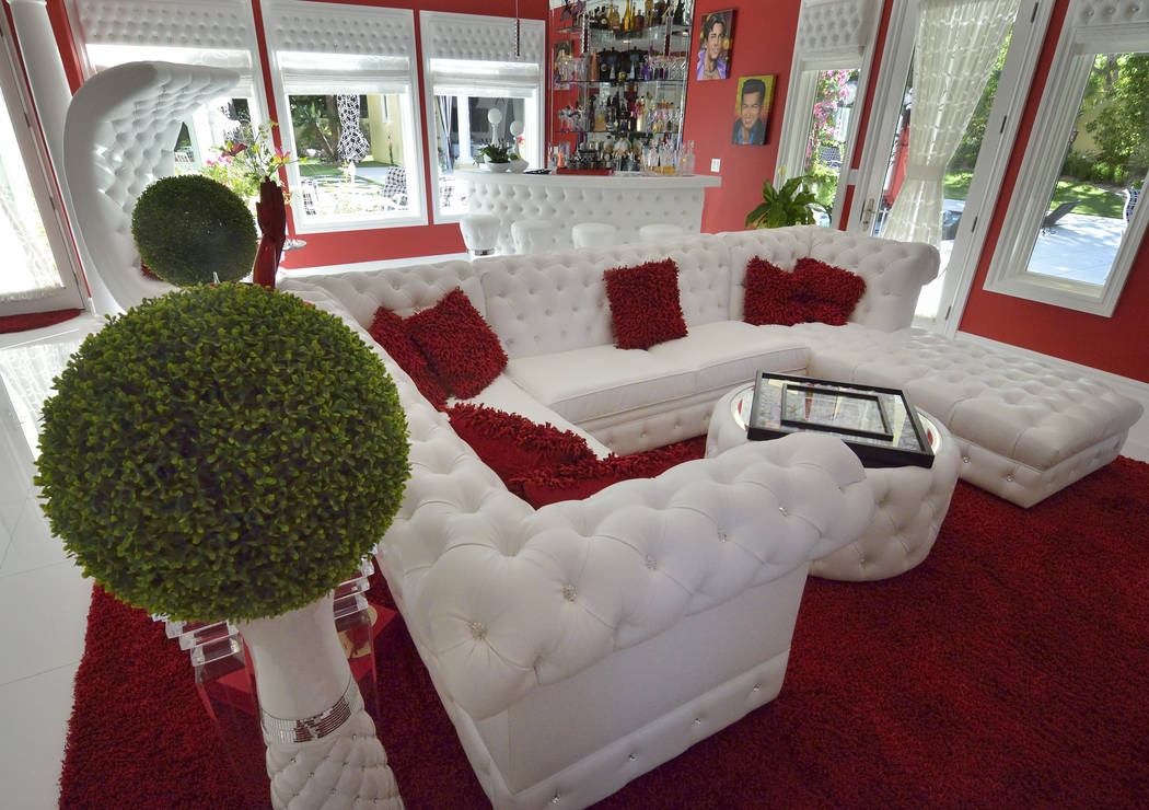 The home's living room has a bar and leads to the pool area that has a cabana. (Bill Hughes Real Estate Millions)