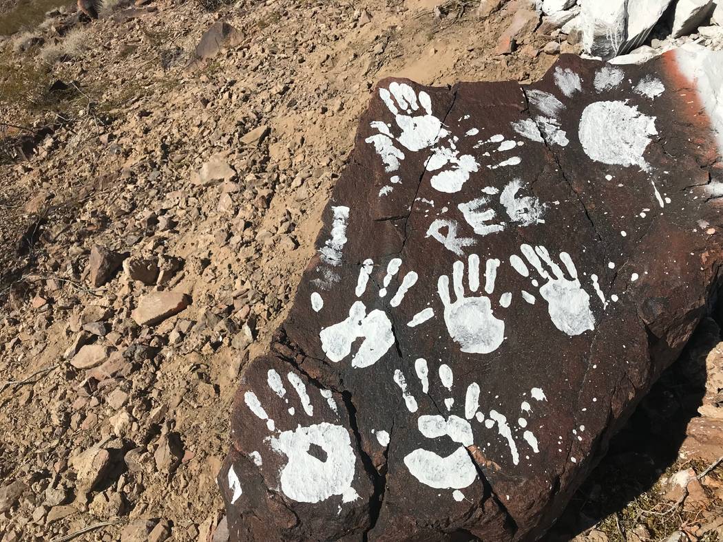 Messages and handprints are left on a rock just below a giant Q in honor of Quinton Robbins on Saturday, Oct. 21, 2017, on the mountain east of Basic High School in Henderson. Friends and family o ...