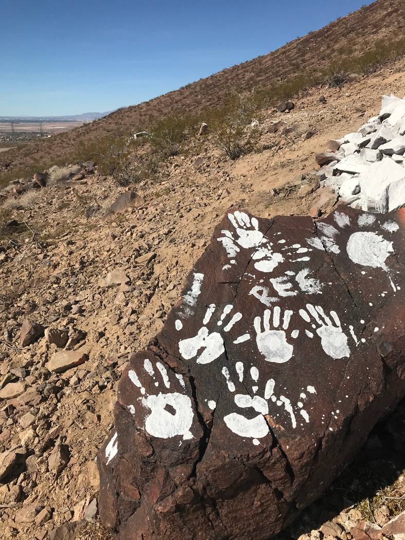 Messages and handprints are left on a rock just below a giant Q in honor of Quinton Robbins on Saturday, Oct. 21, 2017, on the mountain east of Basic High School in Henderson. Friends and family o ...