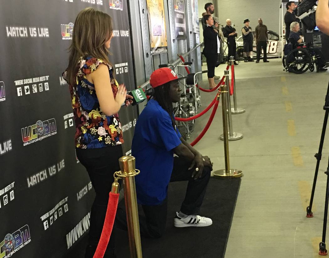 Flavor Flav breaks from an interview with KSNV-TV'S Jillian Lopez to take a knee during the national anthem during Mike Hammer's charity go-kart race at Gene Woods Racing on Sunday, Oct. 22, 2017. ...
