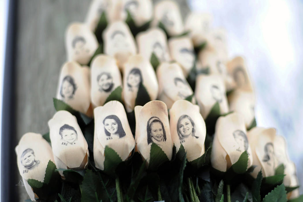 White roses with the faces of victims of the Sandy Hook Elementary School shooting are attached to a telephone pole near the school in Newtown, Conn. on  Jan. 14, 2013. (Jessica Hill/AP)