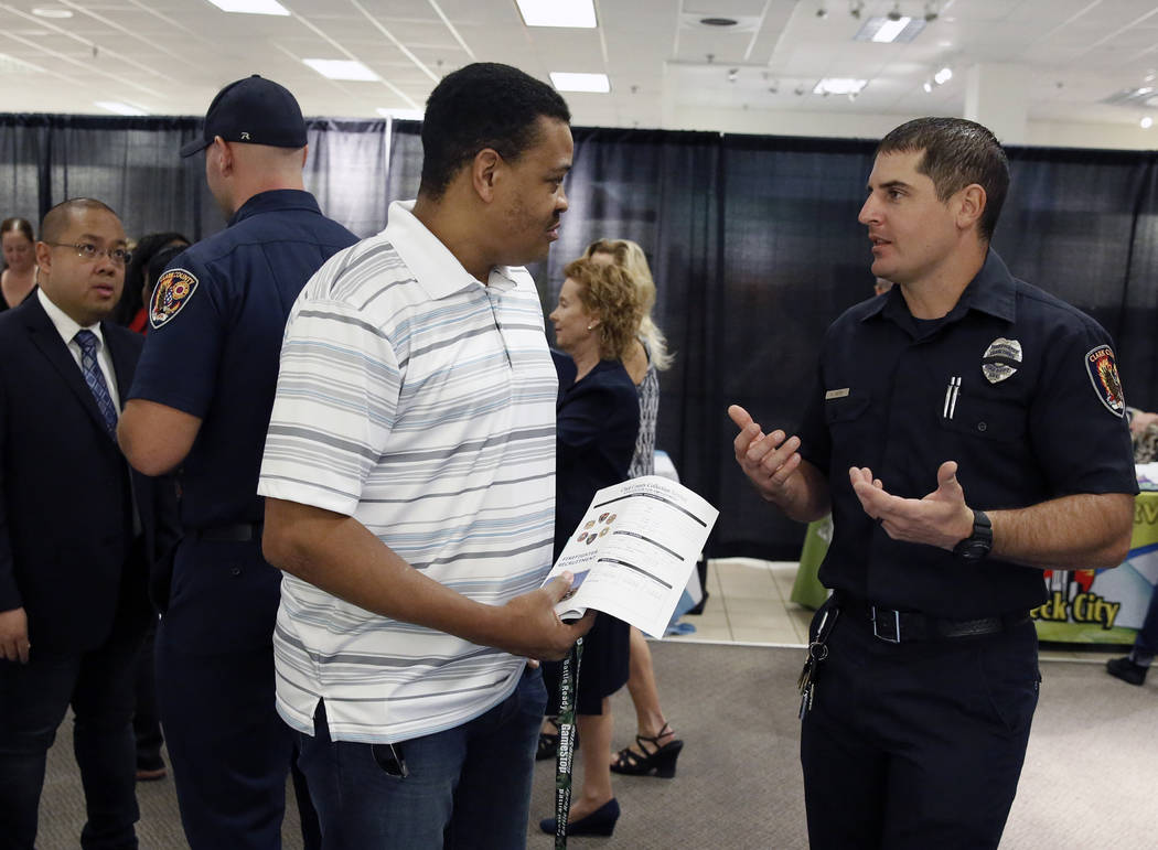 Clark County firefighter, Adam Smith, right, talks to Anthony Lyons of Henderson during the Nevada Day Super Hiring Event on Wednesday, Oct. 25, 2017 at the Boulevard Mall in Las Vegas. Bizuayehu  ...