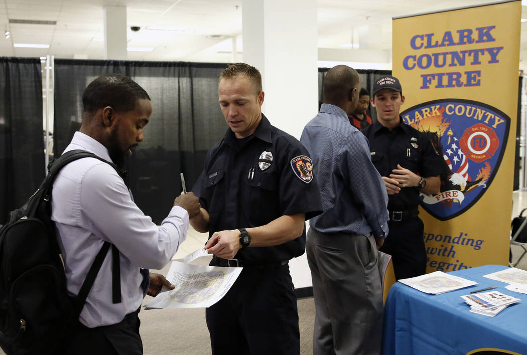Clark County firefighter, James King, second right, talks to Sherrod Lewis during the Nevada Day Super Hiring Event on Wednesday, Oct. 25, 2017 at the Boulevard Mall in Las Vegas. Bizuayehu Tesfay ...