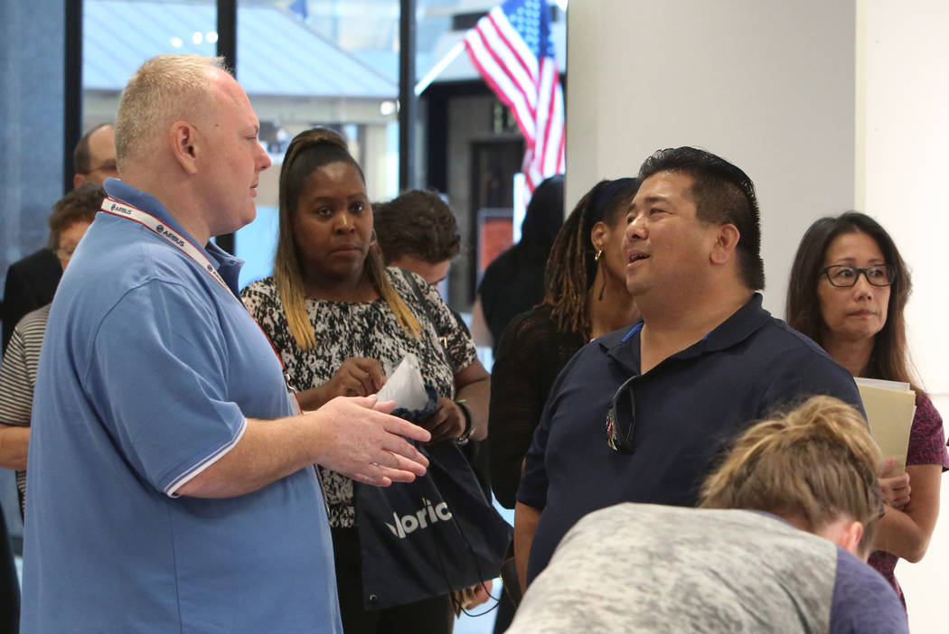 Ted Brown, left, a recruiter with Allegiant Air, speaks to Don Pablo, center, during the Nevada Day Super Hiring Event on Wednesday, Oct. 25, 2017 at the Boulevard Mall in Las Vegas. Bizuayehu Tes ...