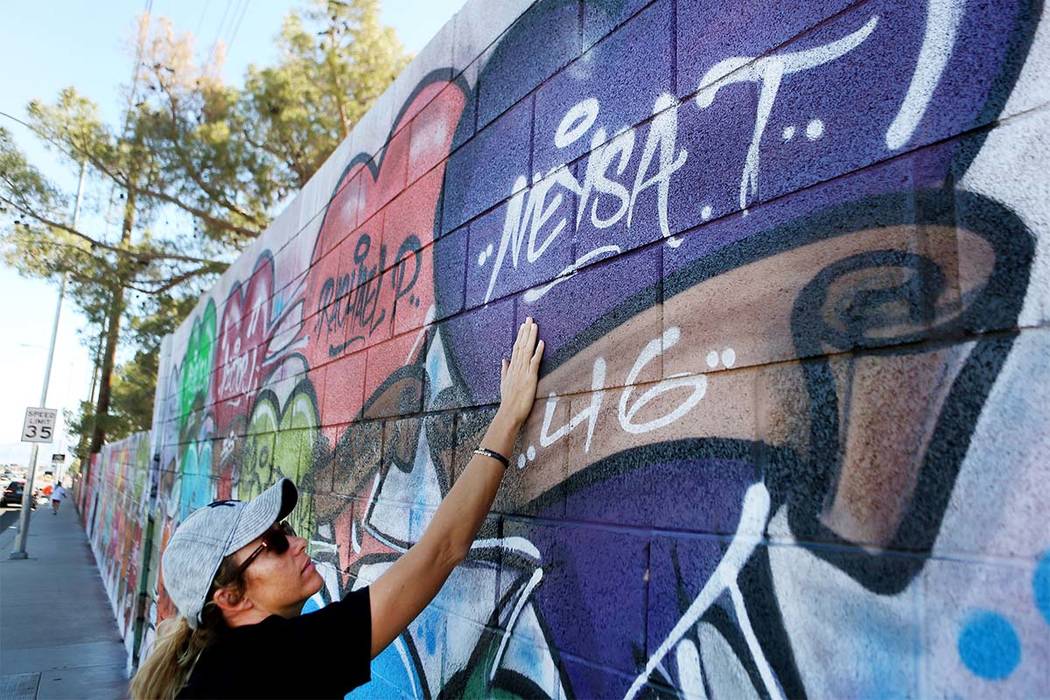 Mynda Smith touches her sister's, Neysa Tonks, name painted on a mural off of Westcliff Drive and Antelope Way in Las Vegas, Tuesday, Oct. 24, 2017. The mural was painted in one night with the nam ...