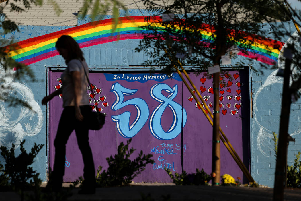 A woman walks past a mural nearby a memorial at the Las Vegas Community Healing Garden in Las Vegas, Monday, Oct. 16, 2017, honoring the victims of the Route 91 Harvest Festival mass shooting. Joe ...