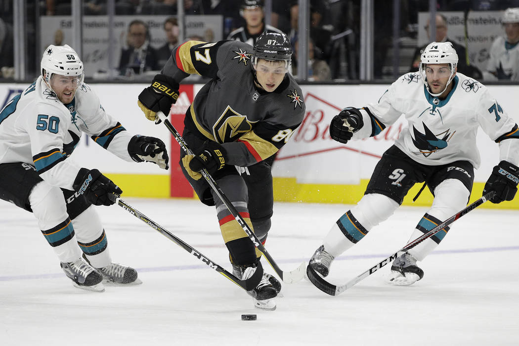 Vegas Golden Knights' Vadim Shipachyov, center, skates through San Jose Sharks' Chris Tierney, left, and defenseman Dylan DeMelo during the first period of an NHL preseason hockey game Sunday, Oct ...