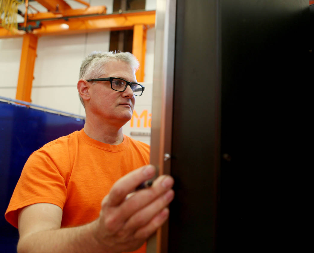Laser operator Scott Troyer demonstrates how the new laser machine can cut precise shapes and lines into metal at General Design & Construction in Las Vegas, Monday, Oct 30, 2017. Elizabeth Br ...