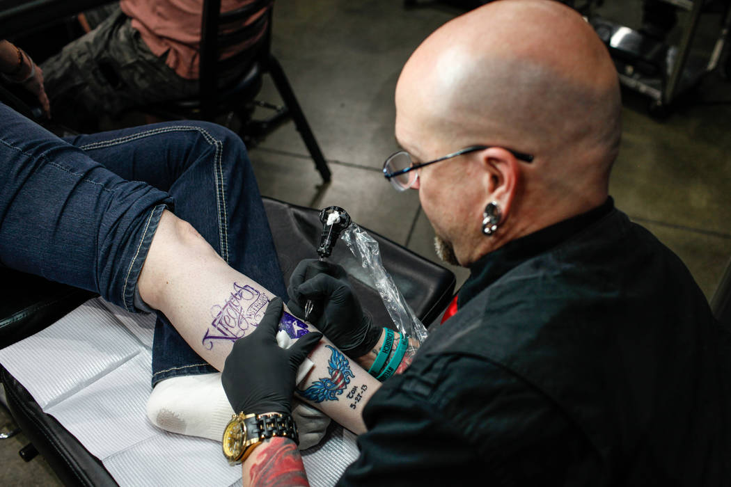 Jill Flynn, 52, left, gets tattooed by Walter &quot;Sausage&quot; Frank, 47, right, both of Las Vegas, during a fundraising event for the victims of the Route 91 Harvest Festival shooting  ...