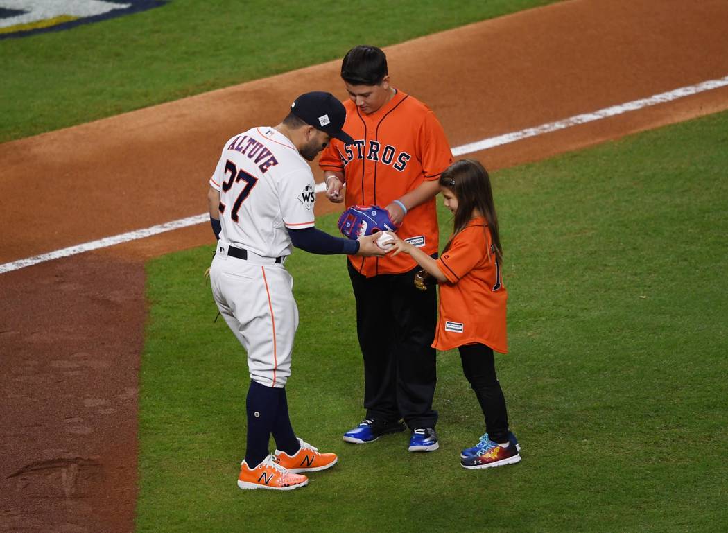 Oct 28, 2017; Houston, TX, USA; Hailey Dawson (right) greets Houston Astros second baseman Jose Altuve (27) after throwing out for the ceremonial first pitch before game four of the 2017 World Ser ...