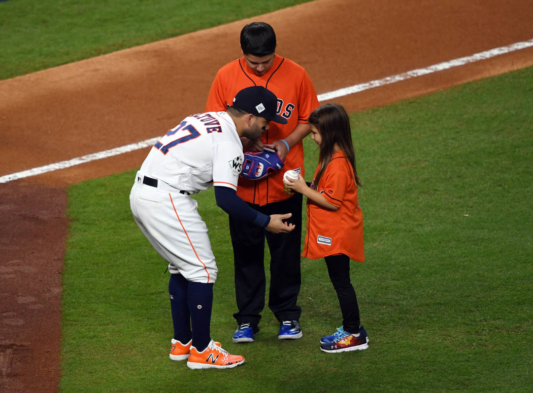 Oct 28, 2017; Houston, TX, USA; Hailey Dawson (right) greets Houston Astros second baseman Jose Altuve (27) after throwing out for the ceremonial first pitch before game four of the 2017 World Ser ...