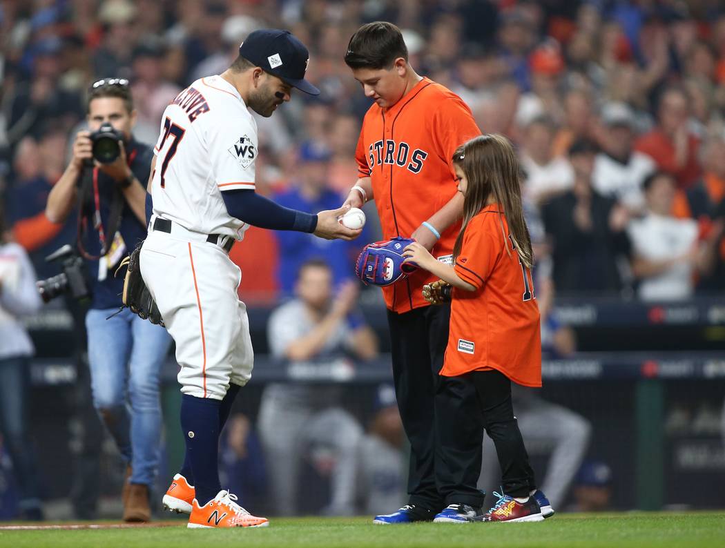Oct 28, 2017; Houston, TX, USA; Hailey Dawson (right) greets Houston Astros second baseman Jose Altuve (27) after throwing out the ceremonial first pitch before game four of the 2017 World Series  ...