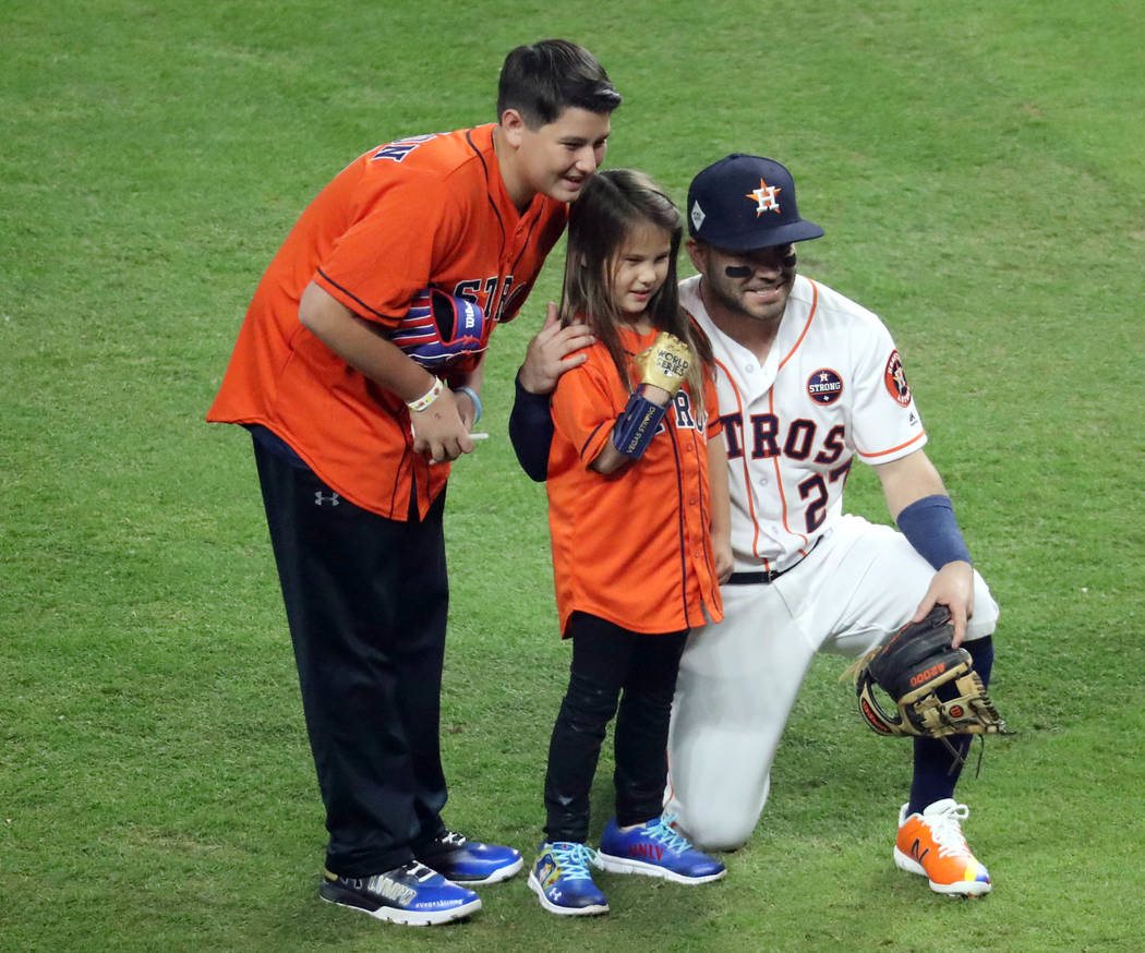 Oct 28, 2017; Houston, TX, USA; Hailey Dawson (middle) poses with Houston Astros second baseman Jose Altuve (27) after throwing out the ceremonial first pitch before game four of the 2017 World Se ...